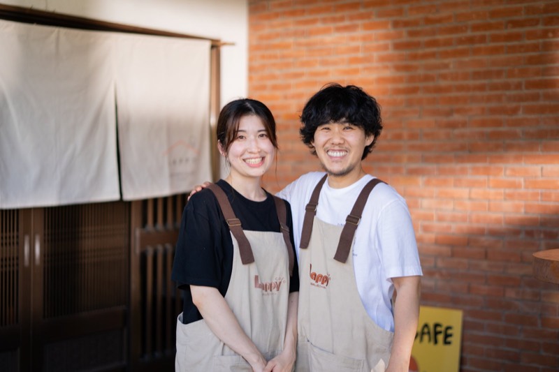 LAPPY CAFEの入口の前に、エプロン姿で並んで立つ大久保佳鈴と尚弥