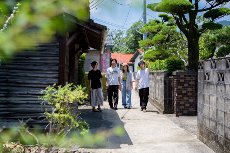 温泉街の路地を、並んで歩く4人